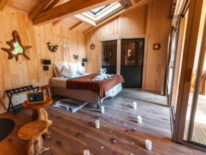 décoration romantique avec bougies, pétales de rose dans une cabane dans les arbres avec spa